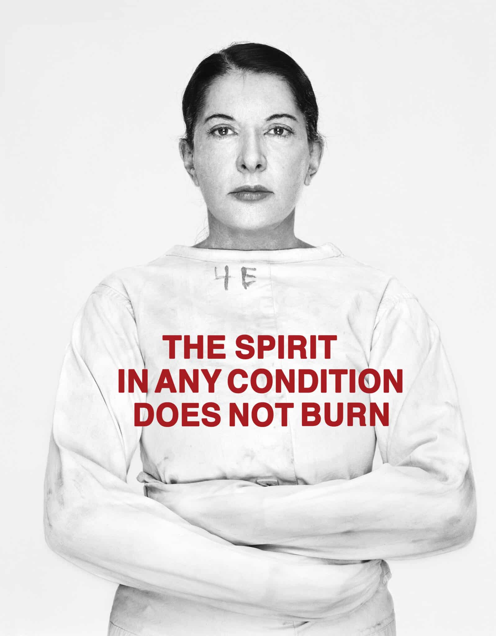 The image depicts a woman with her arms crossed, wearing a white shirt with red text on it. The purpose of the image is to convey a message about the importance of human life and dignity. Here are the details of the image: * A woman: + Standing with her arms crossed + Looking directly at the camera + Her face is neutral, with no visible emotions * A white shirt: + The shirt is plain and simple, without any designs or patterns + It covers the woman's torso and shoulders * Red text on the shirt: + The text reads "THE SPIRIT IN ANY CONDITION DOES NOT BURN" + The words are in all capital letters and are centered on the chest area of the shirt Overall, the image suggests that human life is valuable and should be respected, regardless of one's circumstances or condition. The use of red text on a white shirt creates a bold and striking visual effect, drawing attention to the importance of this message.